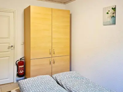 a bedroom with a bed and a wooden cabinet at 5 person holiday home in LONEVÅG-By Traum in Lonevåg