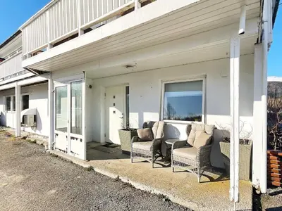 a covered porch with chairs and windows on a house at 6 person holiday home in AVERØY-By Traum in Stein
