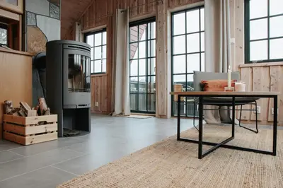 a living room with a table and a stove at Fanøy Island Lodge in Fanoyna
