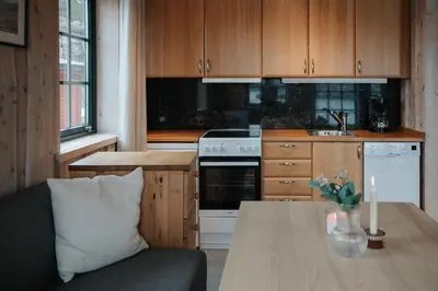 a kitchen with wooden cabinets and a table with a couch at Fanøy Island Lodge in Fanoyna