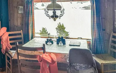 a dining room table with chairs and a window at 4 Bedroom Nice Home In Etne in Etnesjøen