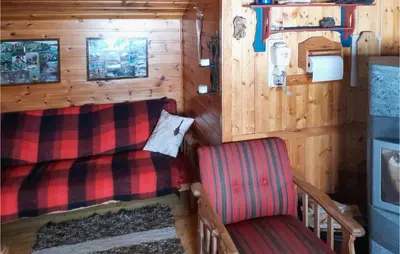 a room with a bed and a chair in a cabin at 4 Bedroom Nice Home In Etne in Etnesjøen