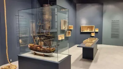 a museum exhibit with a boat in a glass case at Runde Miljøsenter & Opplev Runde in Runde