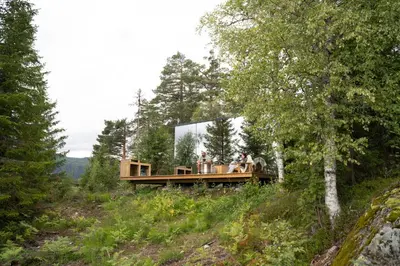 a house on a hill with people sitting on it at Vidsyn Midjås in Vistad