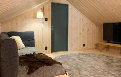 a living room with a couch and a television at Stunning Home In Øyer With Sauna in Øyer