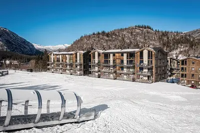 a ski lodge in the snow in front of a building at Mountain nest in Hemsedal close to the ski slopes in Hemsedal