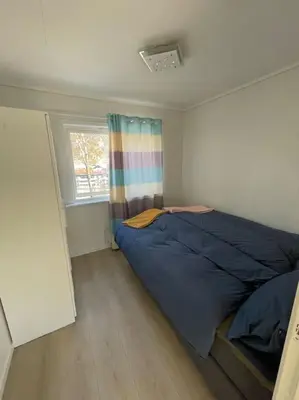 a bedroom with a bed and a window at Lovely 2 bedroom apartmen with free parking in Bergen
