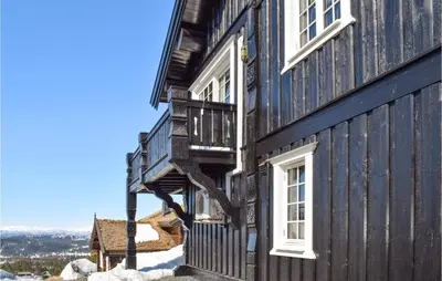 a wooden house with white windows on the side of it at Gorgeous Home In Rauland in Rauland