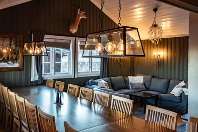 a dining room with a table and a couch at Storsten 730 in Trysil
