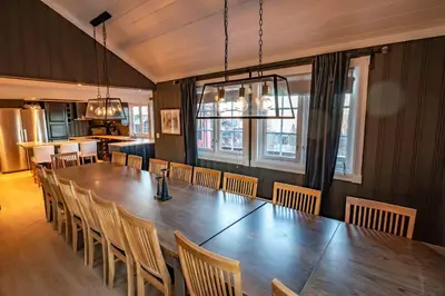 a dining room with a large wooden table and chairs at Storsten 730 in Trysil