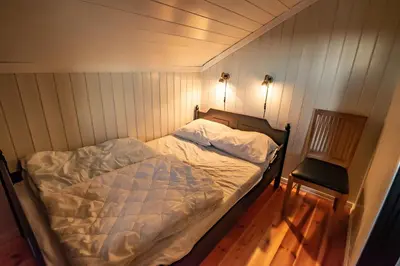 a small bedroom with a bed and a chair at Storsten 730 in Trysil