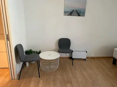 two chairs and a white table in a room at Marken Studio Apartments in Bergen