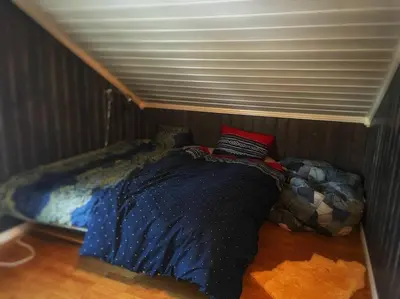 a bedroom with a bed in the corner of a room at Stor hytte med 4 soverom og panoramautsikt over Tinnsjøen ved Rjukan og Gaustatoppen in Håkånes