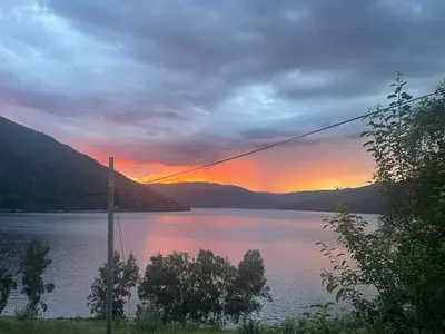 a sunset over a body of water with mountains at Stor hytte med 4 soverom og panoramautsikt over Tinnsjøen ved Rjukan og Gaustatoppen in Håkånes
