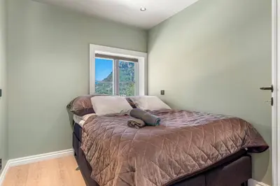 a bedroom with a large bed with a window at Trolltunga View in Tysso