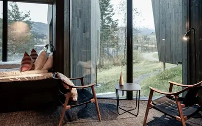 a room with a couch and chairs and a large window at Elva Hotel in Vossevangen