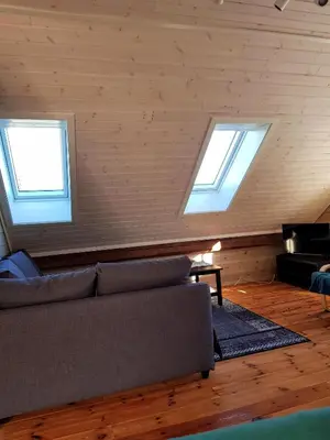 a living room with a couch and two windows at Leilighet Vikaparken Hardangerfjord in Hatlestrand