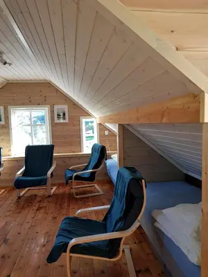 a room with two chairs and a bed in a cabin at Leilighet Vikaparken Hardangerfjord in Hatlestrand