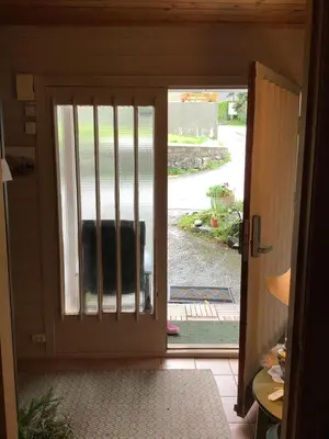 an open door with a view of a yard at Line på Hauane1 in Volda