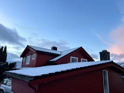 a red house with snow on the roof at Line på Hauane1 in Volda