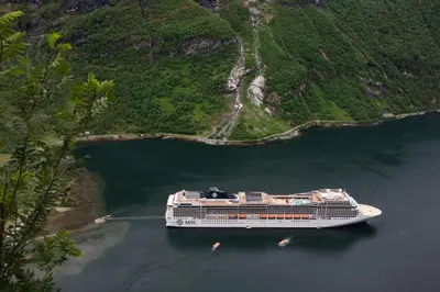 a cruise ship in a body of water at Westerås Gard in Geiranger