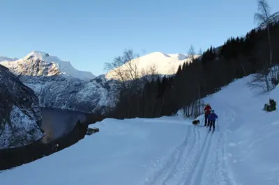 a group of people skiing down a snow covered slope at Westerås Gard in Geiranger