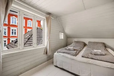 a small bedroom with two beds and a window at Dinbnb Homes I 4-Bedroom Historical House in Romantic Surroundings in Bergen