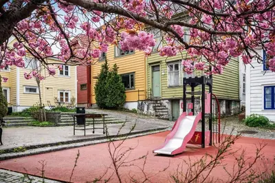 a playground with a slide in front of a house at Dinbnb Homes I 4-Bedroom Historical House in Romantic Surroundings in Bergen