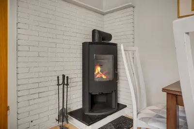 a black fireplace in a white brick wall at Dinbnb Homes I 4-Bedroom Historical House in Romantic Surroundings in Bergen