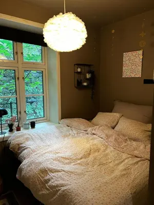 a bedroom with a large bed and a chandelier at Modern Apartment in the center of Bergen in Bergen