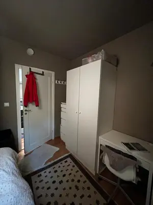 a bedroom with a bed and a red shirt hanging on a closet at Modern Apartment in the center of Bergen in Bergen