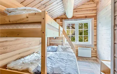 a bedroom with two bunk beds in a wooden cabin at Beautiful Home In Dalholen With Sauna in Furuhovde