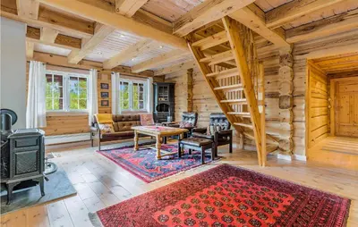 a living room with a staircase in a log cabin at Beautiful Home In Dalholen With Sauna in Furuhovde