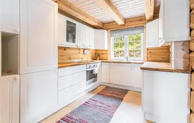 a kitchen with white cabinets and a wooden ceiling at Beautiful Home In Dalholen With Sauna in Furuhovde