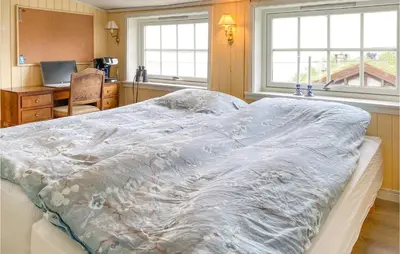 a bedroom with a bed with a blanket on it at Stunning Home In Ålesund With Kitchen in Ålesund