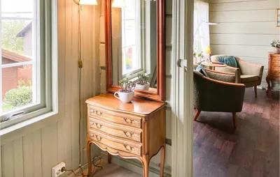 a room with a dresser and a mirror and a chair at Stunning Home In Ålesund With Kitchen in Ålesund