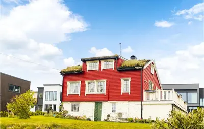 a red house with grass on the roof at Stunning Home In Ålesund With Kitchen in Ålesund