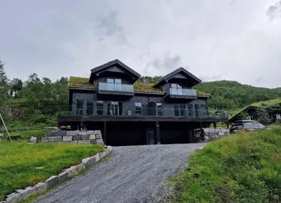 a house with a grass roof on a dirt road at Resvegen 63 in Stranda