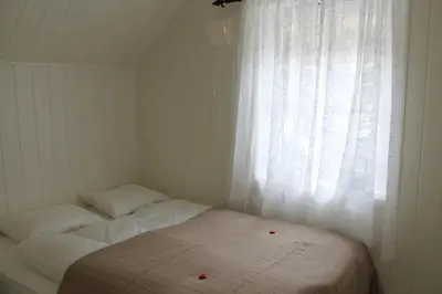 a small bedroom with a bed and a window at Rosendal Hyttetun in Rosendal