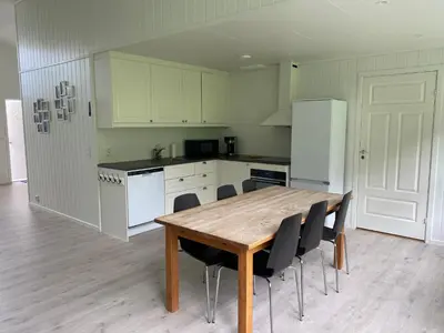 a kitchen with a wooden table and black chairs at Rosendal Apartments Motellet in Rosendal
