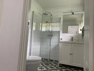 a bathroom with a shower and a toilet and a sink at Rosendal Apartments Motellet in Rosendal