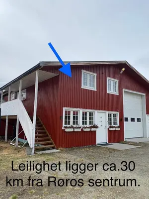 a red barn with a blue arrow on it at Leilighet Sølendet, i Brekken ved Røros in Røros