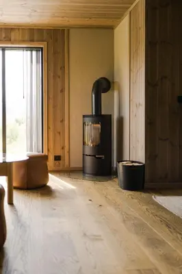 a living room with a wood stove in a room at Exclusive Suite in the Sunnmøre Alps, Near Geiranger & Hjørundfjord in Stranda