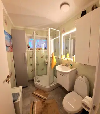 a bathroom with a shower and a toilet and a sink at Gjesterom til leie i et privat hus in Brumunddalen