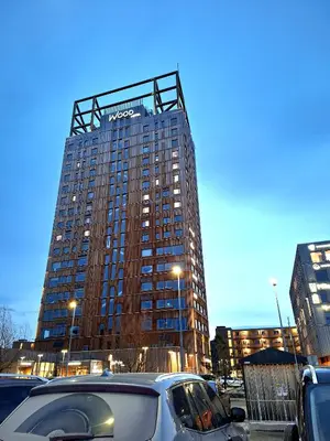 a tall building with cars parked in front of it at Gjesterom til leie i et privat hus in Brumunddalen