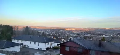 a view of a city with houses and mountains at Gjesterom til leie i et privat hus in Brumunddalen