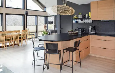 a kitchen with a black counter and some chairs at 5 Bedroom Nice Home In Hemsedal in Hemsedal