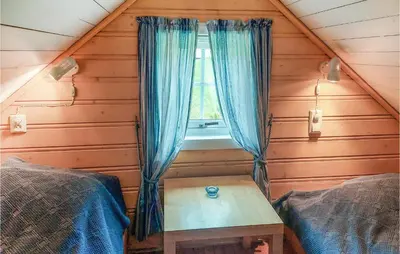 a room with a window and a table in a cabin at Cozy Home In Mosvik With House Sea View in Mosvik