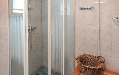 a bathroom with a shower with a basket at Cozy Home In Mosvik With House Sea View in Mosvik