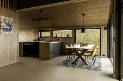 a kitchen and dining room with a table and chairs at Moderne hytte på Norefjell in Noresund